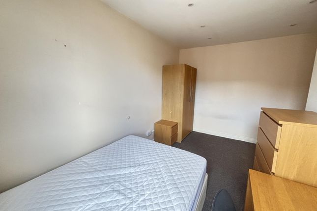 A Simple Bedroom Featuring A Double Bed, Wooden Wa...