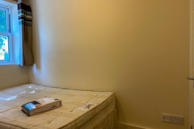 A Cozy Bedroom With A Neatly Made Bed Placed Again...