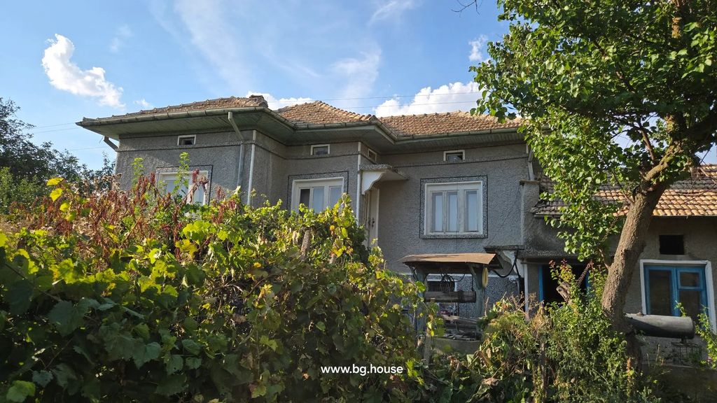Property photo 1 of 64 Two-Story House With Gray Walls And Tiled Roof, Surrounded By Greenery And A Tree In Front.