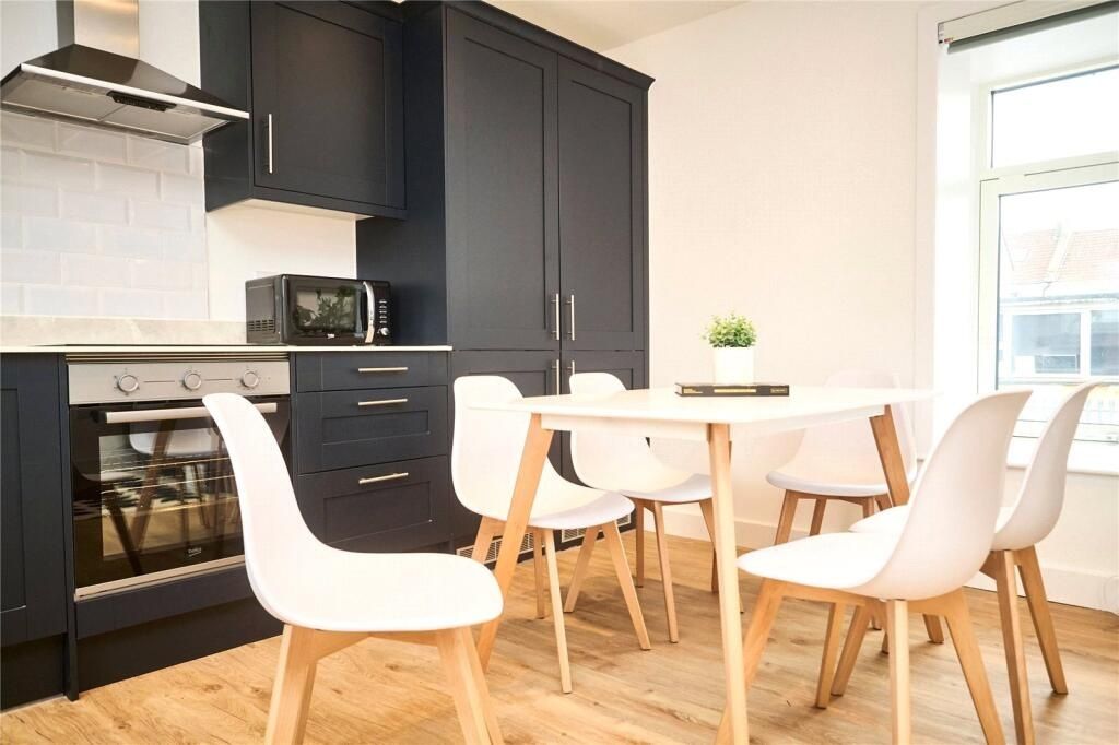 Property photo 3 of 13 Bright And Modern Kitchen Featuring Sleek Black Ca...