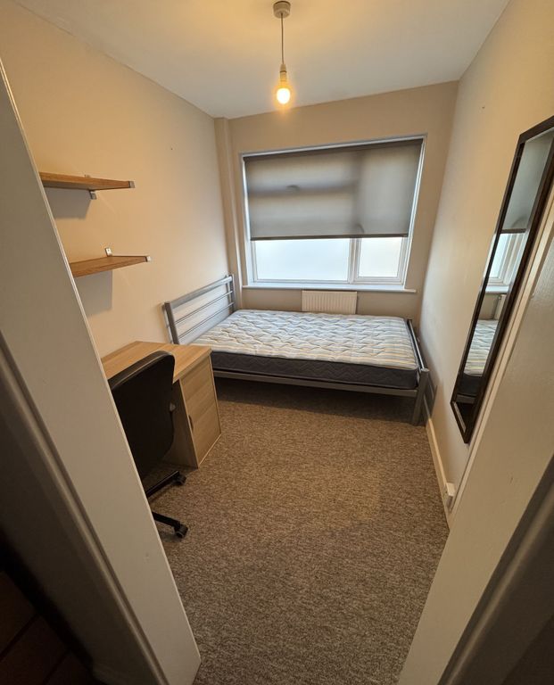 Property photo 3 of 14 A Cozy Single Bedroom Featuring A Simple Bed, A De...