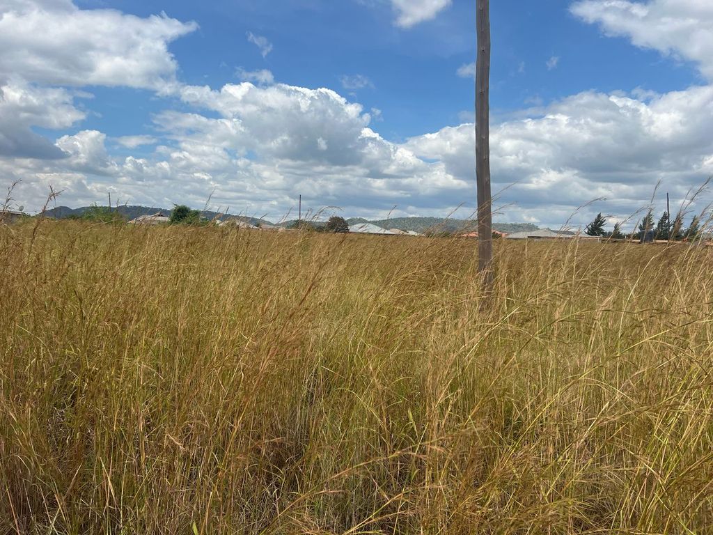 Property photo 1 of 4 Tall Golden Grass Field With A Lone Wooden Utility Pole In The Foreground, Blue Sky And Clouds Above, And Distant Hills And Houses On The Horizon.