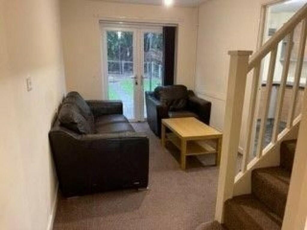 Property photo 2 of 8 Cozy Living Room Featuring Comfortable Black Leath...