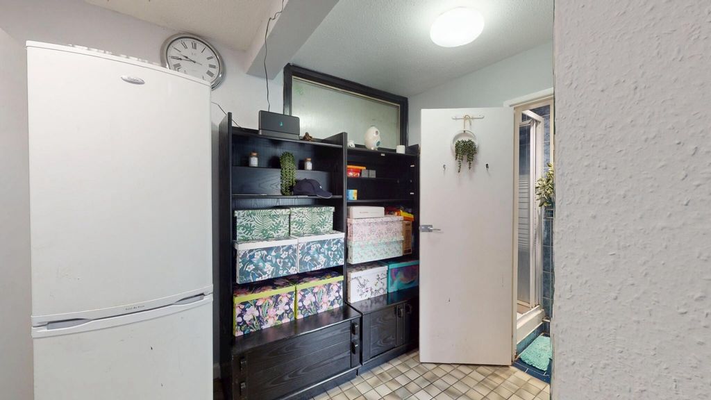 Property photo 2 of 11 A Compact Kitchen Area Featuring Shelves And Stora...