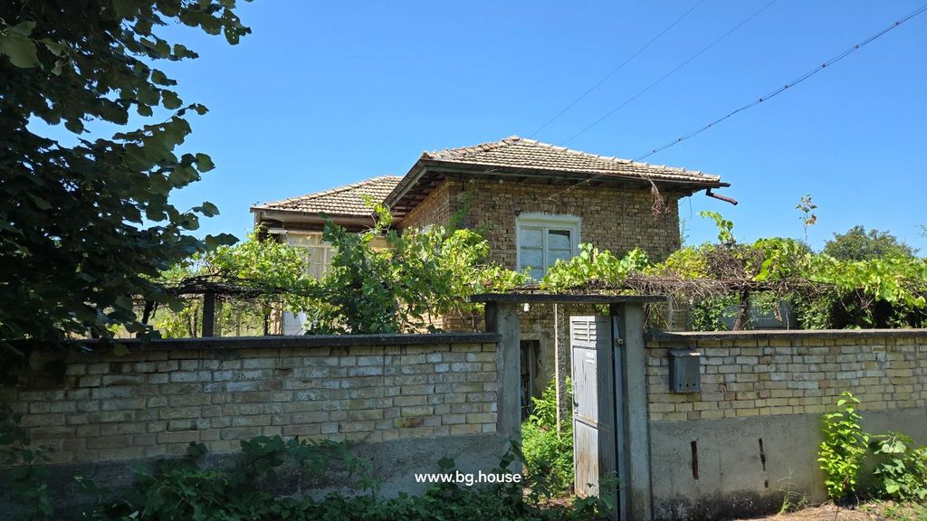 Property photo 1 of 67 Two-Storey Brick House With Tiled Roof Behind A Brick Wall With Metal Gate And Green Vines Growing On Trellis