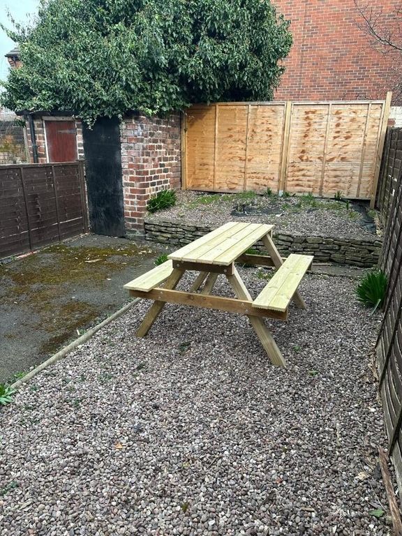 Property photo 1 of 11 A Cozy Garden Space Featuring A Wooden Picnic Tabl...
