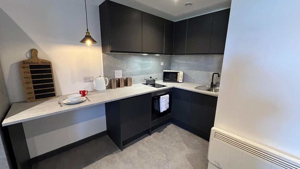 Property photo 2 of 10 A Modern Compact Kitchen Featuring Sleek Black Cab...