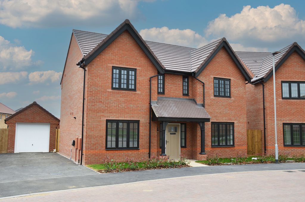 Property photo 1 of 10 A Modern Brick House With A Detached Garage Sits On A Paved Driveway Under A Cloudy Sky.