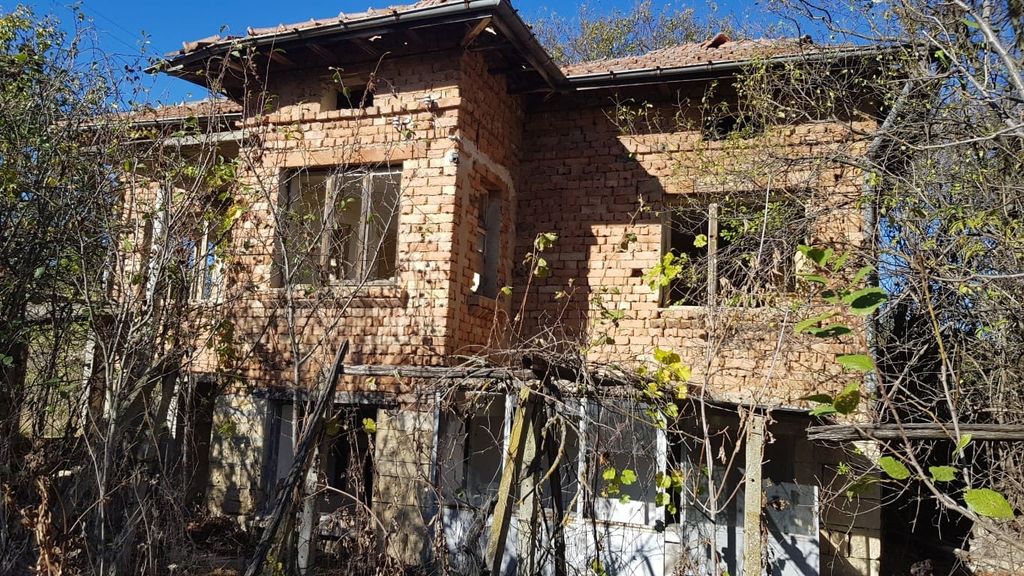 Property photo 2 of 34 Front View Of The Two-Storey Brick House With Tiled Roof, Partially Covered By Leafless Trees And Bushes