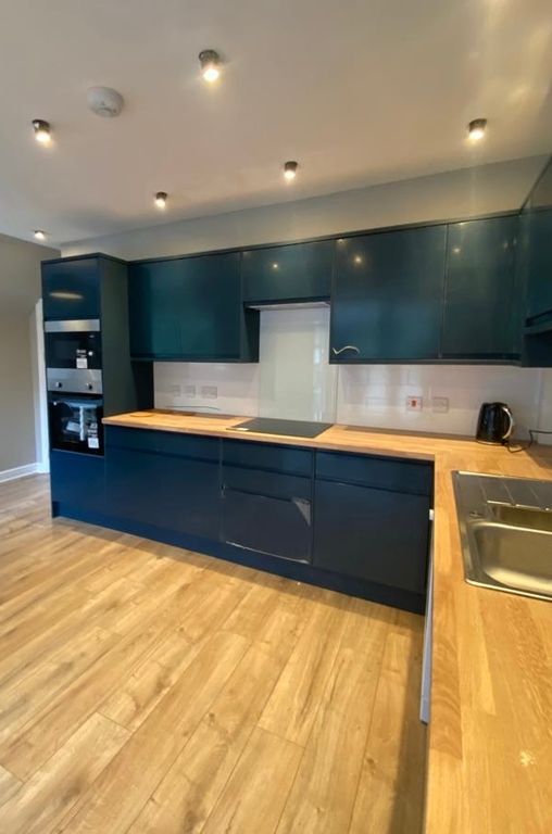 Property photo 3 of 20 Modern Kitchen Featuring Sleek, Dark Blue Cabinetr...