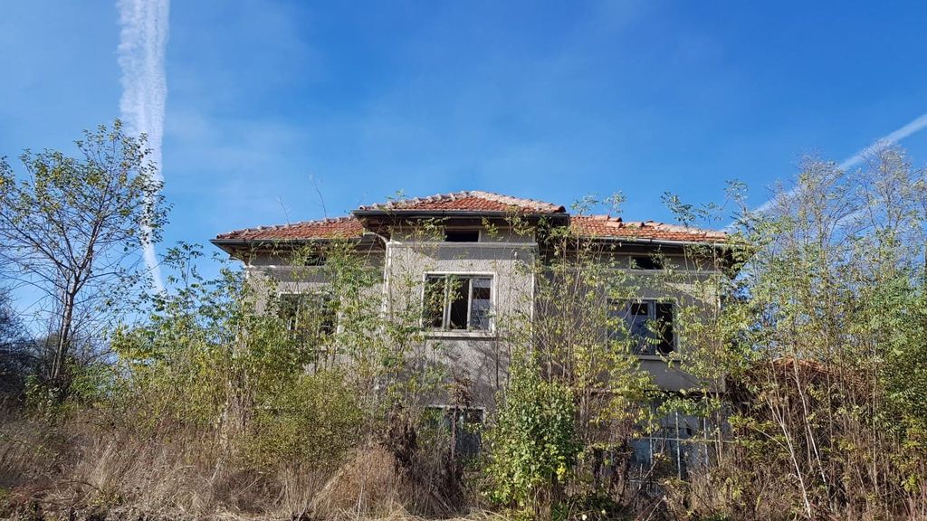Property photo 1 of 50 View Of The Two-Storey Bulgarian House With A Tiled Roof Partially Obscured By Dense Bushes And Trees In The Garden.
