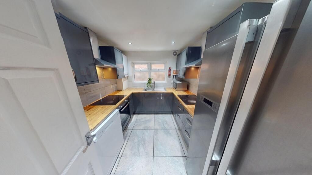 Property photo 3 of 11 A Modern Kitchen Featuring Sleek Cabinetry, Built-...