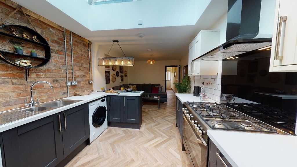 Property photo 2 of 7 Modern Kitchen Featuring Sleek Black Cabinets, Sta...