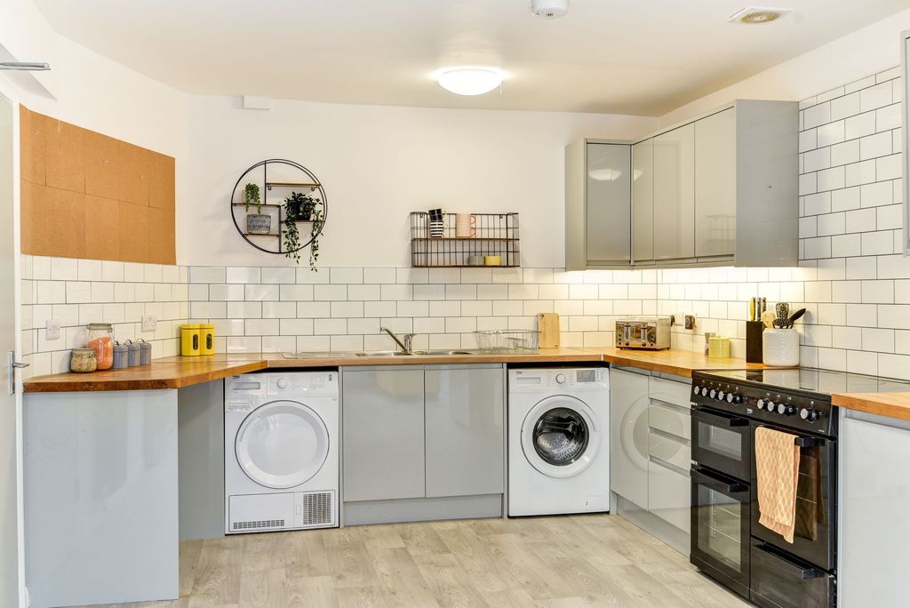 Property photo 3 of 4 Bright And Modern Kitchen Featuring Sleek Grey Cab...