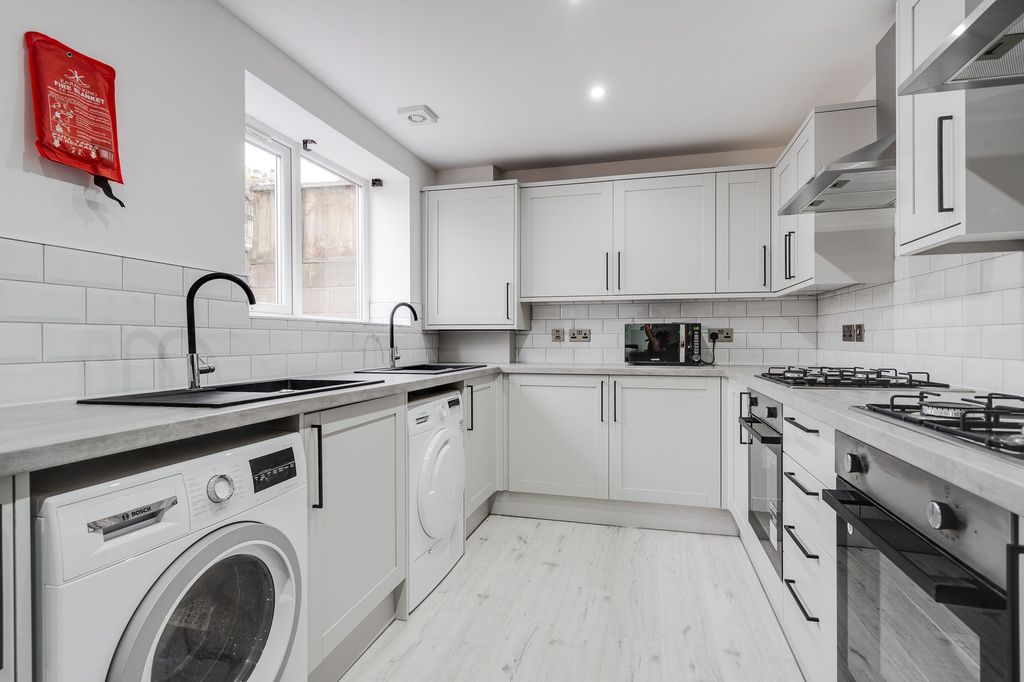 Property photo 3 of 5 A Bright, Modern Kitchen Featuring White Cabinetry...