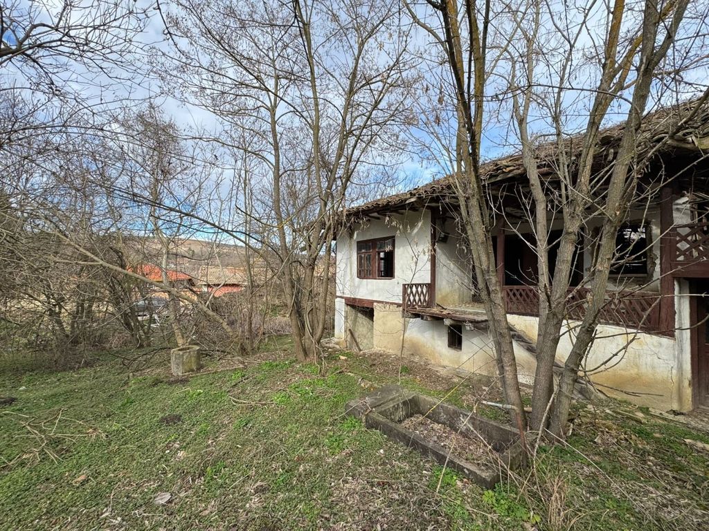 Property photo 2 of 11 Side Perspective Of The Old House Showing White Plaster Walls, Wooden Balcony, And Surrounding Bare Trees.