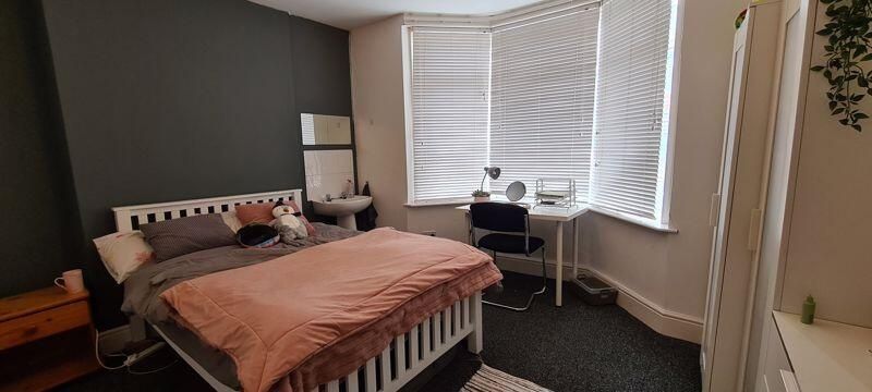 Property photo 2 of 8 A Cozy And Well-Lit Bedroom Featuring A Comfortabl...