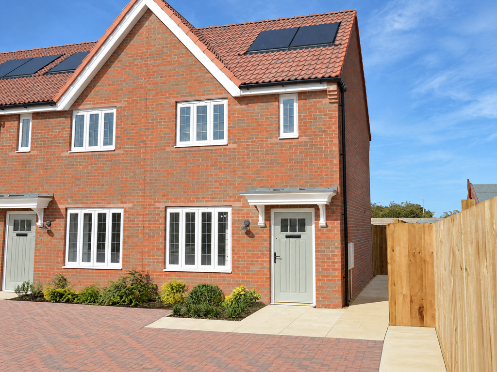 Property photo 1 of 10 A Modern Red-Brick House With White-Framed Windows And Solar Panels Stands Before A Clear Blue Sky