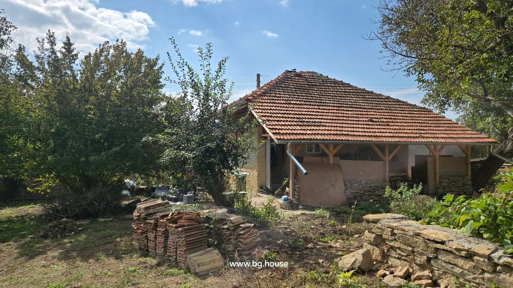 Property photo 2 of 40 Side View Of Brick House With Tiled Roof, Garden Area With Stacked Roof Tiles And Trees