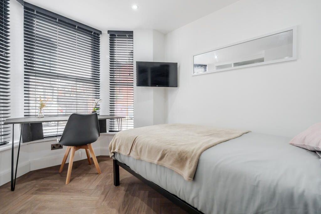 Property photo 1 of 15 A Modern, Well-Lit Master Bedroom Featuring A Comf...