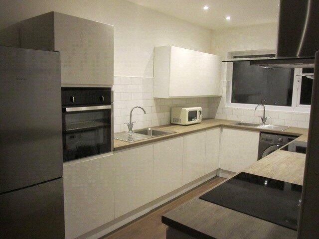 Property photo 3 of 10 Modern Kitchen With Sleek White Cabinets And Integ...