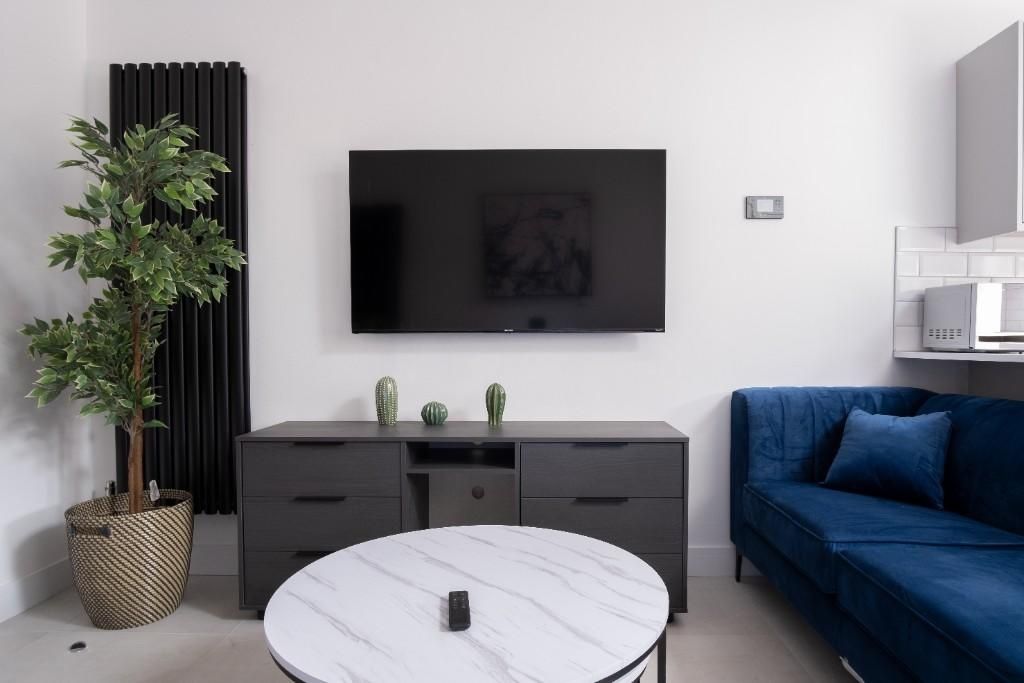 Property photo 3 of 15 A Modern Living Room Featuring A Sleek Mounted Fla...