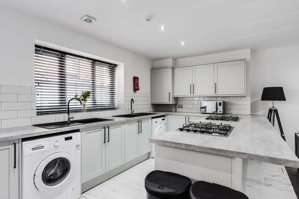 Property photo 2 of 5 Modern And Bright Kitchen With White Cabinetry, Bl...