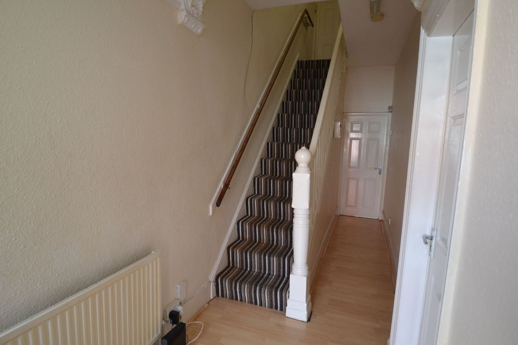 Property photo 3 of 25 Narrow Hallway With A Striped-Carpet Staircase And...