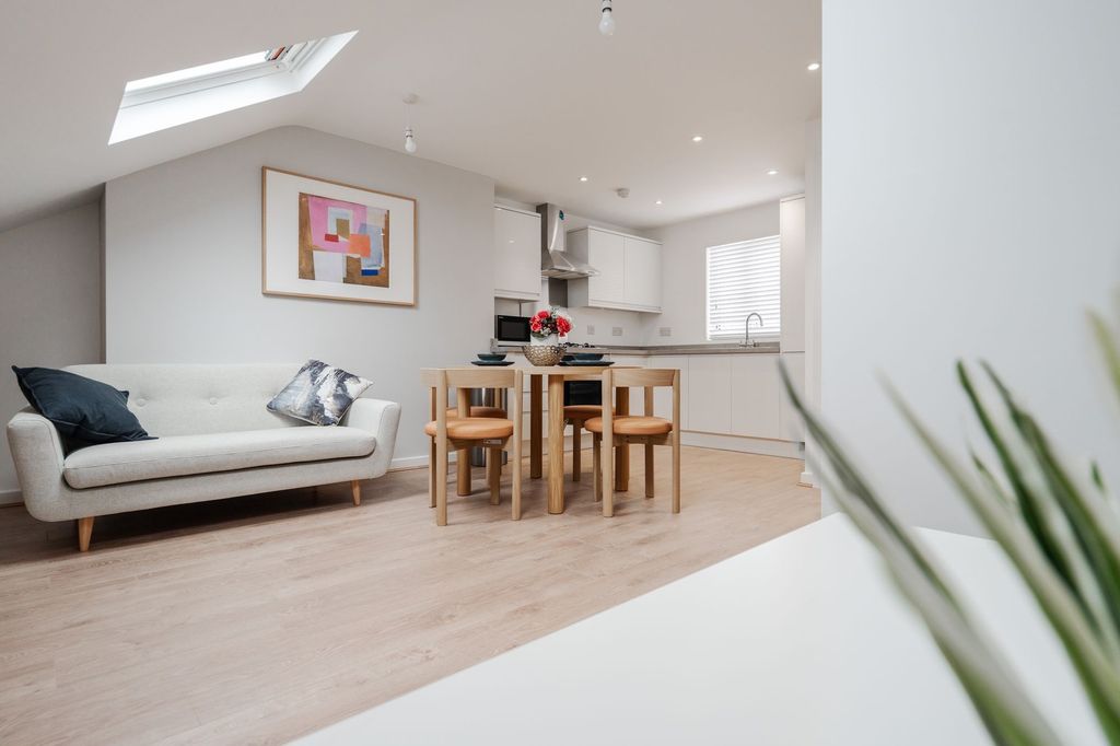 Property photo 1 of 9 A Bright And Airy Living Room Featuring A Modern, ...