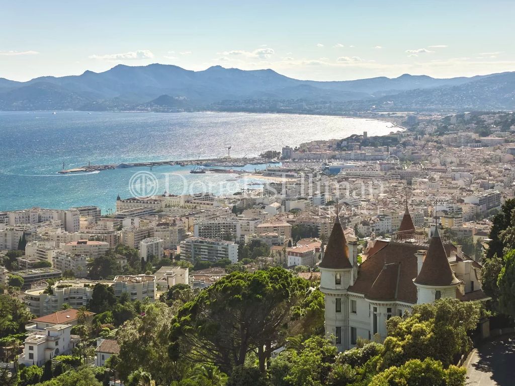 Property photo 2 of 12 A Scenic View Of A Coastal City With A Castle-Like Building In The Foreground, Overlooking The Sea And Mountains In The Distance.