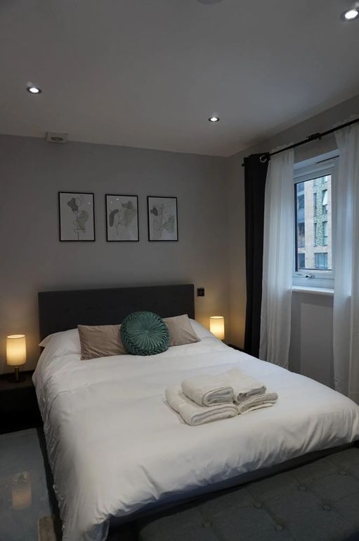 Property photo 2 of 8 A Stylish And Cozy Master Bedroom Featuring A Neat...