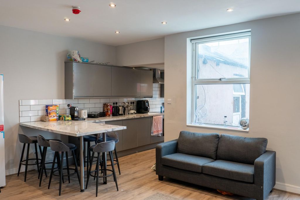 Property photo 2 of 34 A Modern, Well-Lit Living Room Featuring A Dark So...