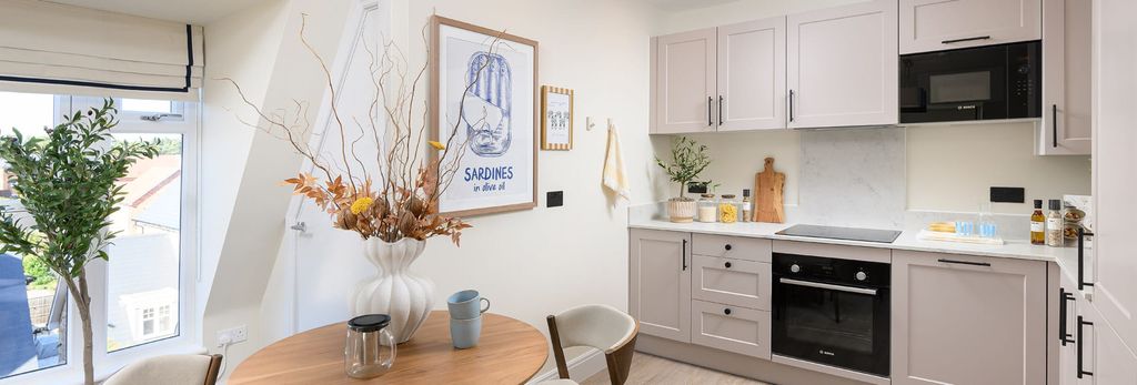 Property photo 3 of 5 Kitchenette With Light Grey Tones, Circular Wooden Dining Table In Foreground.