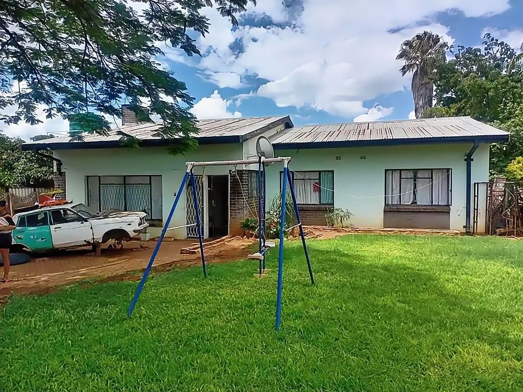 Property photo 1 of 17 Single-Story Pale Blue House With A Metal Roof; Blue Swing Set In The Front Yard And A Turquoiseâ€‘White Pickup To The Left.
