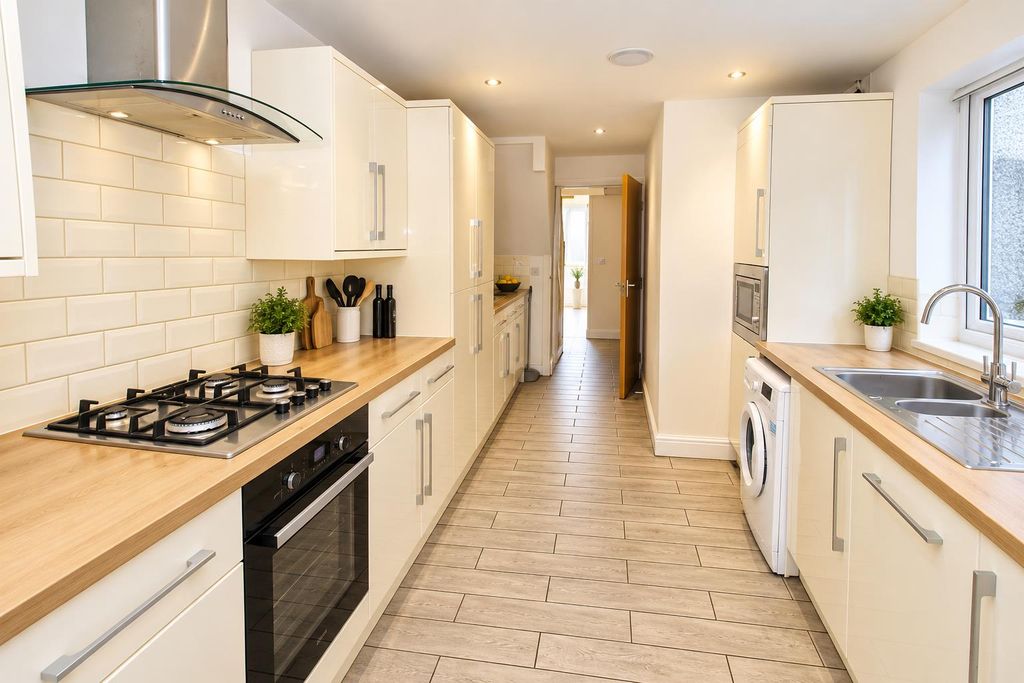 Property photo 1 of 22 Modern Galley Kitchen With Warm Wood Accents.Png