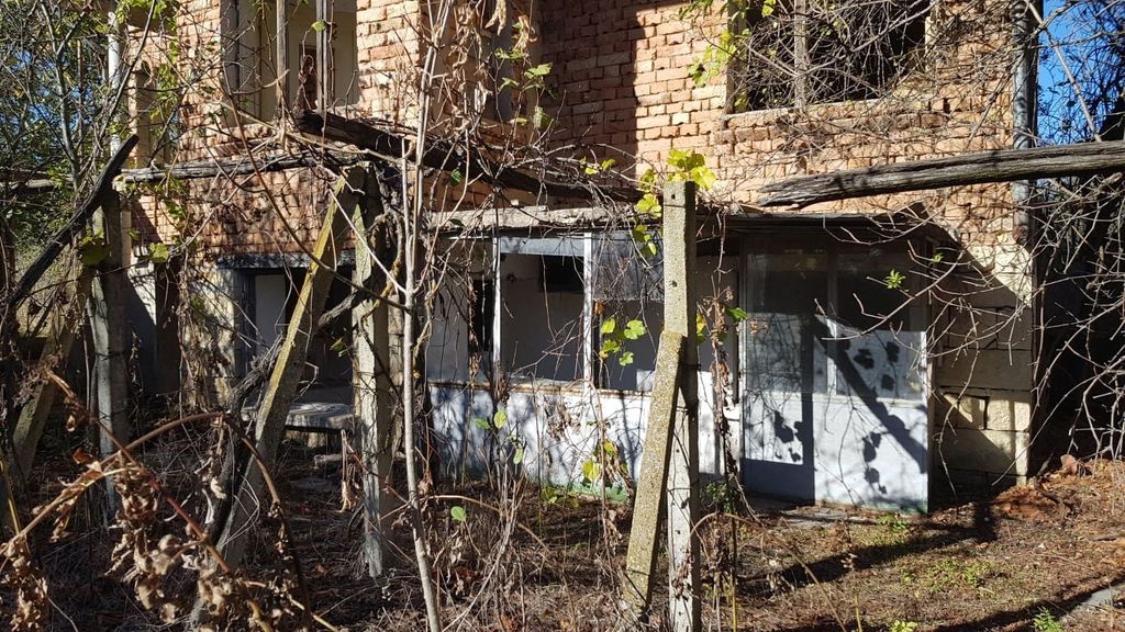 Property photo 3 of 34 Close-Up Of The Lower Level Enclosed Porch Area Of The Brick House With Surrounding Overgrown Garden