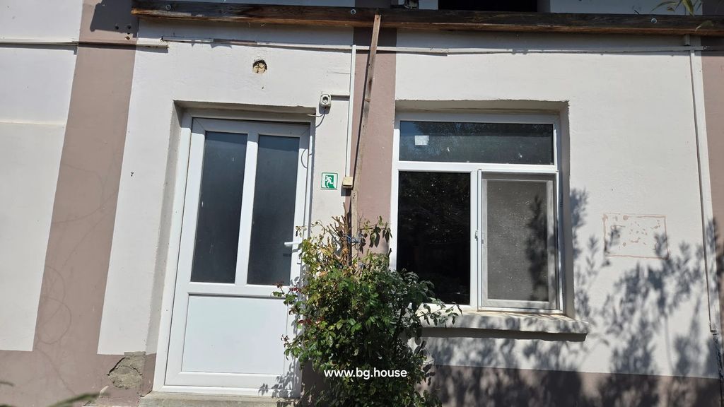 Property photo 3 of 100 White Building Wall With Beige Stripes, Door, Window, And Small Bush In Front Under Sunlight.