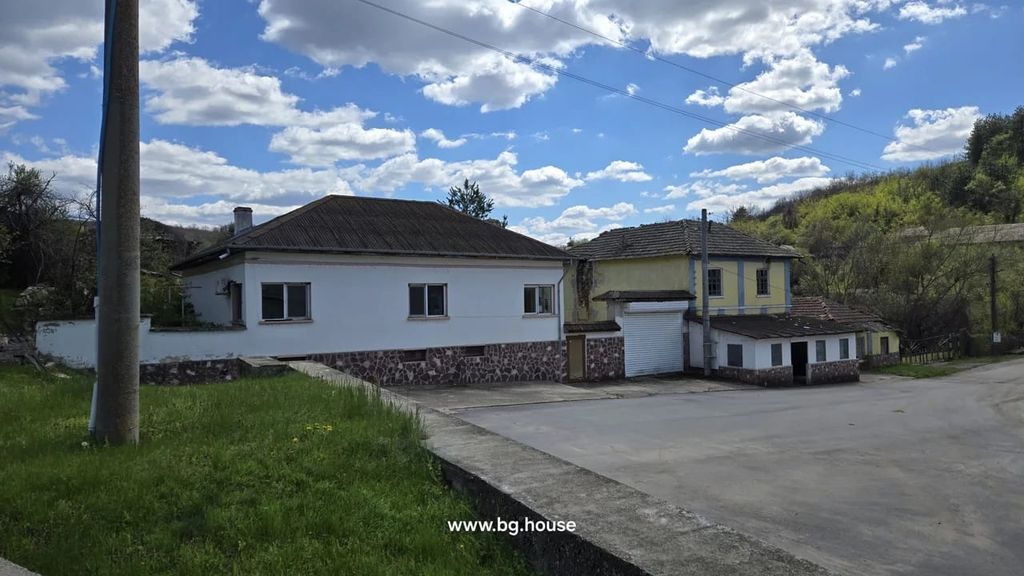 Property photo 1 of 40 Front View Of A White House With Stone Foundation And A Garage Door, Under A Partly Cloudy Sky.
