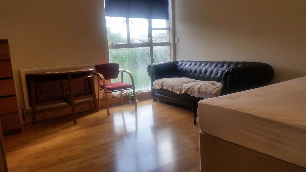 Property photo 2 of 10 A Cozy Living Room Featuring A Black Leather Sofa,...