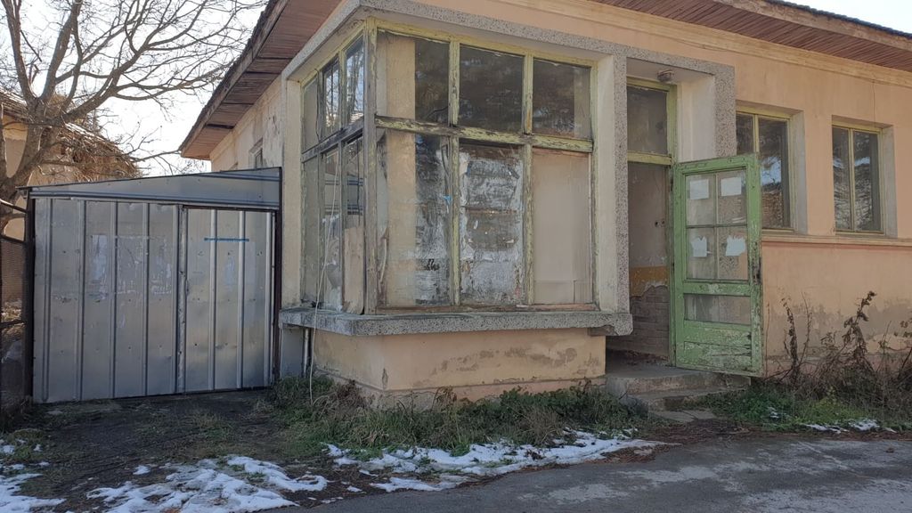 Property photo 3 of 35 Close-Up Of The Bakery Corner Featuring Large Windows, A Green Door, And Surrounding Dry Grass With Snow Patches.