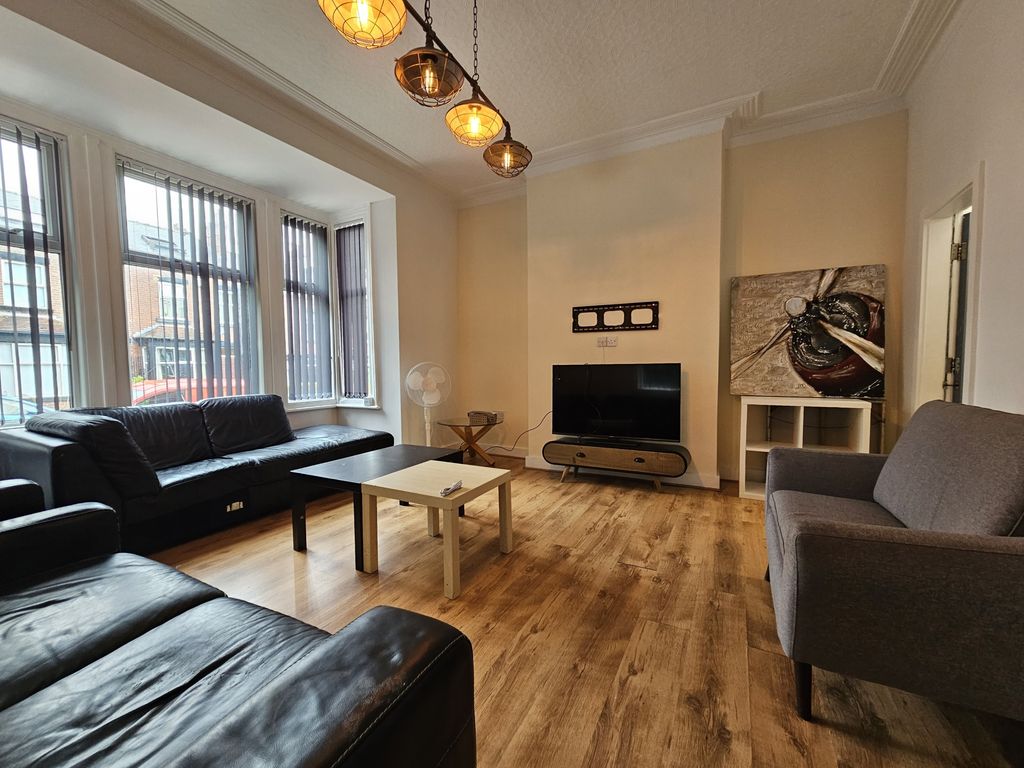 Property photo 3 of 18 A Well-Lit Living Room Featuring Three Sofas Arran...