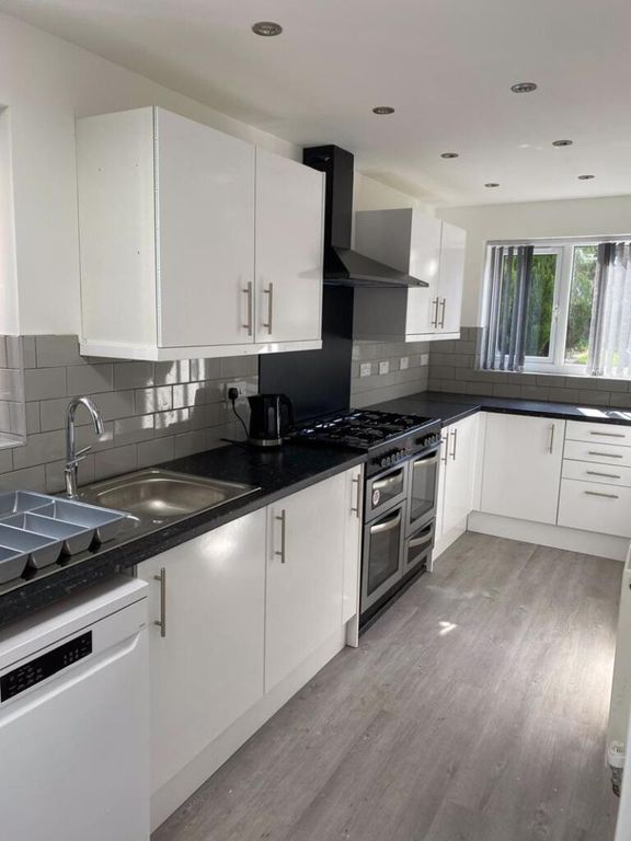 Property photo 2 of 13 Bright And Modern Kitchen Featuring Sleek White Ca...