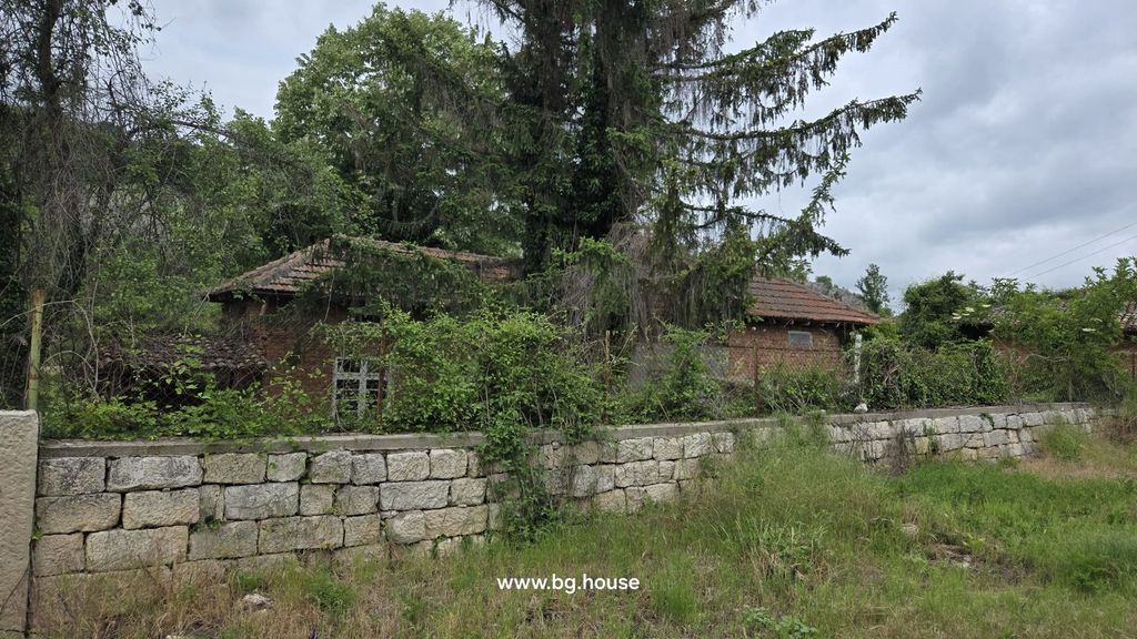 Property photo 2 of 26 View Of An Overgrown Garden With Tall Grass, A Stone Wall, And A Brick House Partially Obscured By Trees And Bushes.