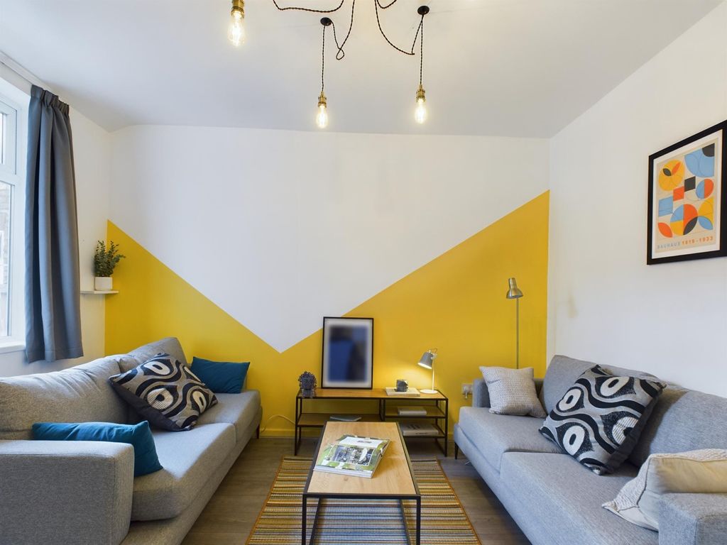 Property photo 2 of 16 This Vibrant Living Room Features Stylish Grey Sof...