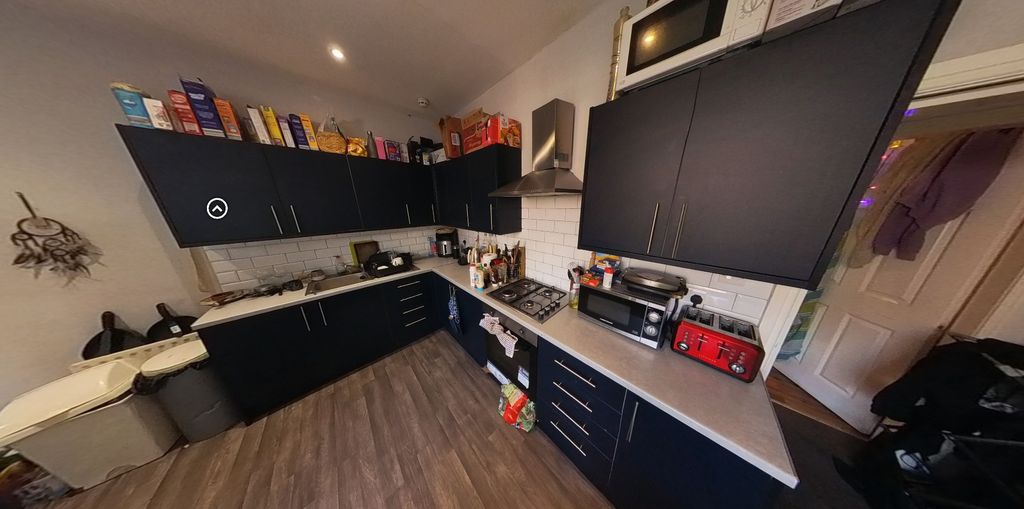 Property photo 2 of 7 A Modern Kitchen Featuring Sleek Black Cabinetry W...