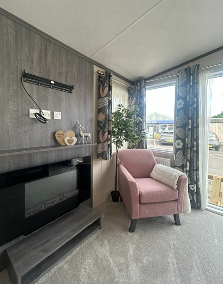 Property photo 3 of 3 Cosy Lounge Corner With Pink Armchair, Feature Fireplace And Patio Doors