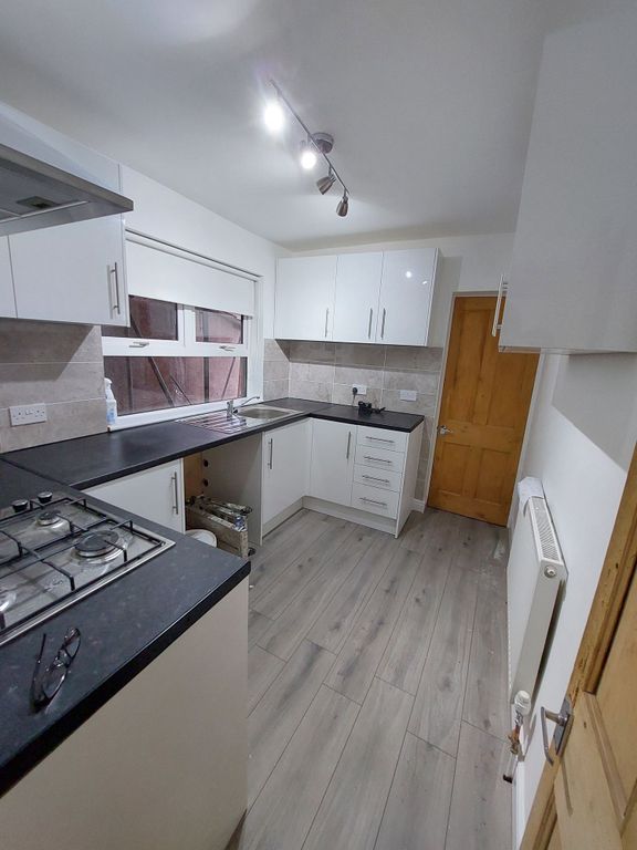 Property photo 2 of 6 Modern Galley Kitchen With Sleek White Cabinets, B...