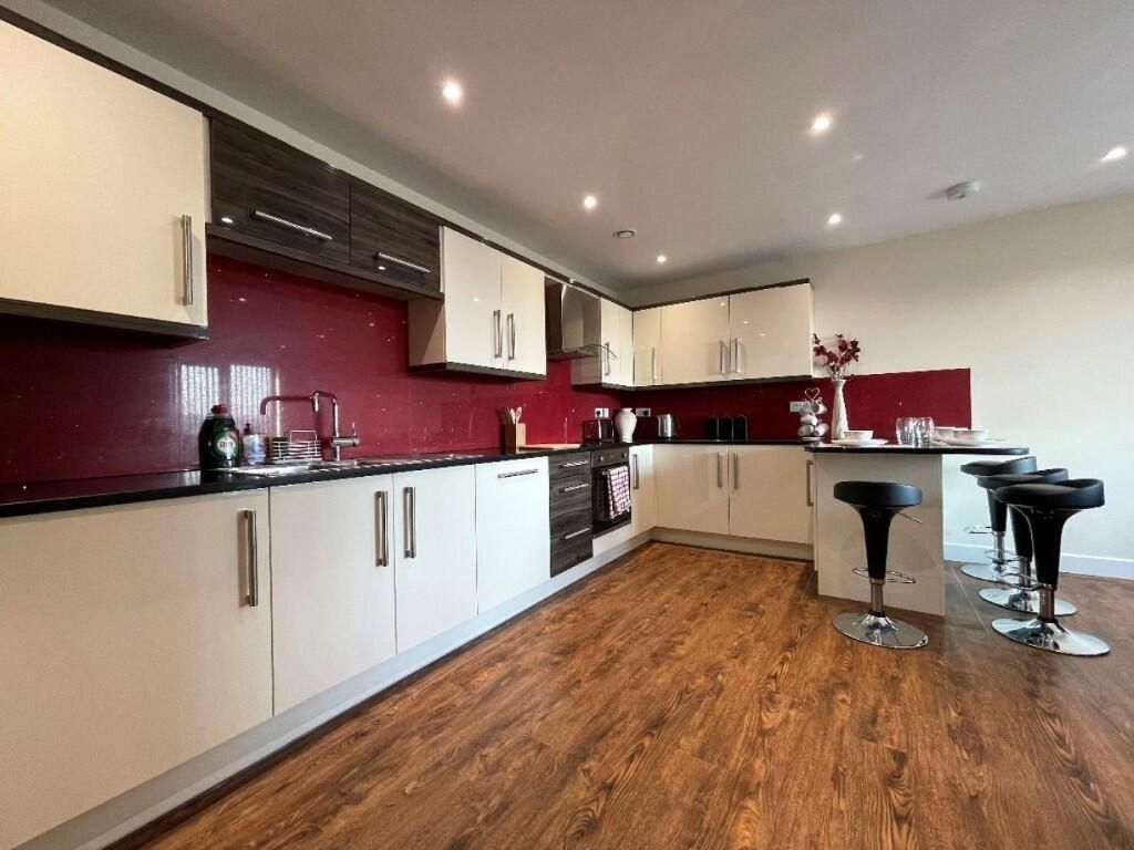 Property photo 3 of 13 A Modern, Spacious Kitchen Featuring Sleek White c...