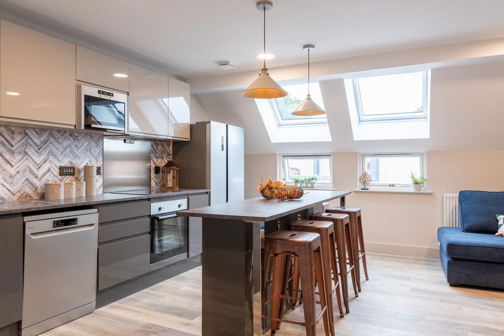 Property photo 1 of 13 Bright And Modern Kitchen Featuring Sleek White Ca...