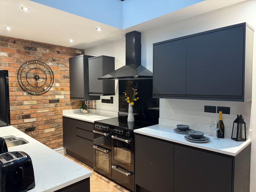 Property photo 3 of 8 Modern, Stylish Kitchen Featuring Dark Cabinetry, ...